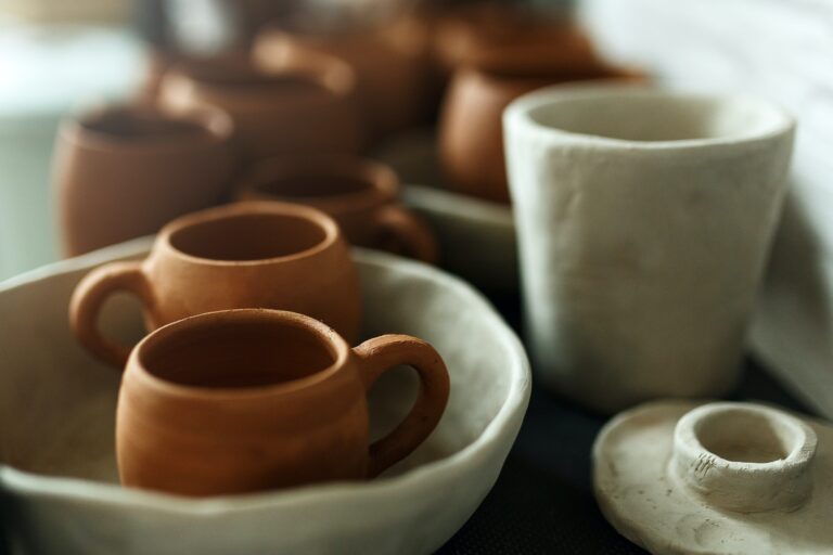 A close-up of various drying clay tableware on a shelf. A pottery studio concept. Craftmade dishes