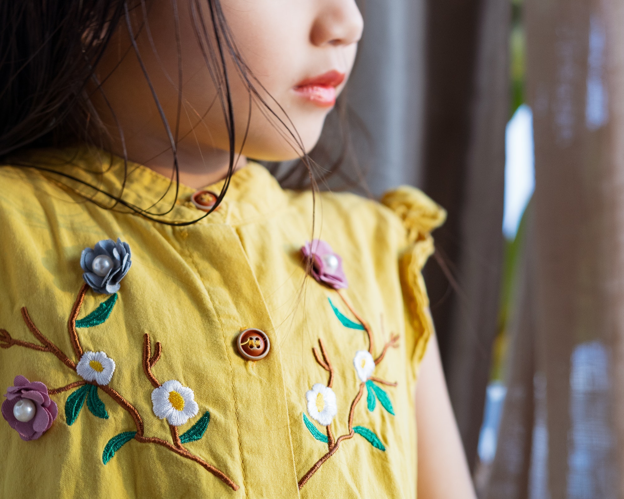 Close up of embroidery flowers on a dress of a child.