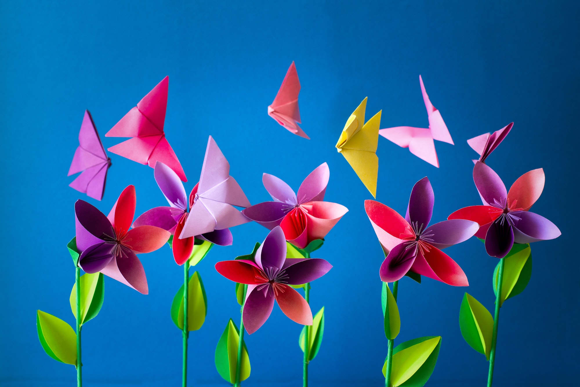 Origami paper flowers, butterflies, clouds and sun. Paper art craft