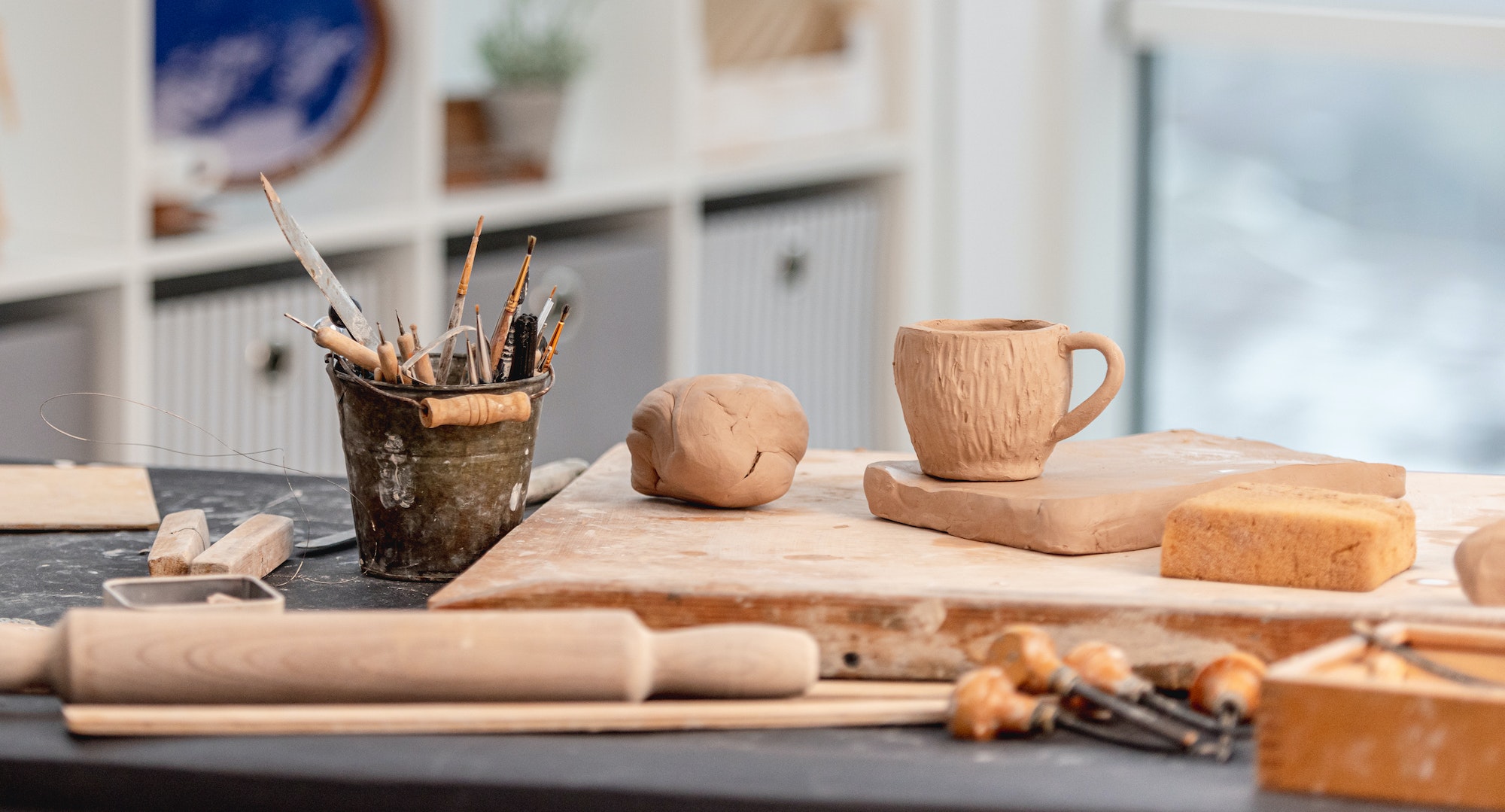 Pottery tools, cup and clay at workshop